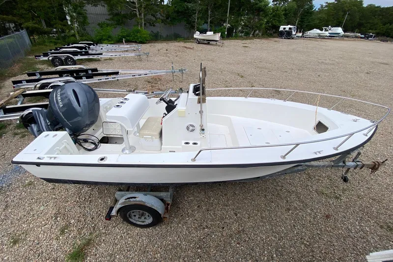 Slide: The Image of 1995 Sailfish 19 boat on trailer with Yamaha outboard motor, parked outdoors. - 2