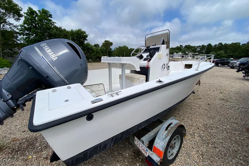 Slide: The Image of 1995 Sailfish 19 boat on trailer with Yamaha outboard, parked on gravel lot. - 3