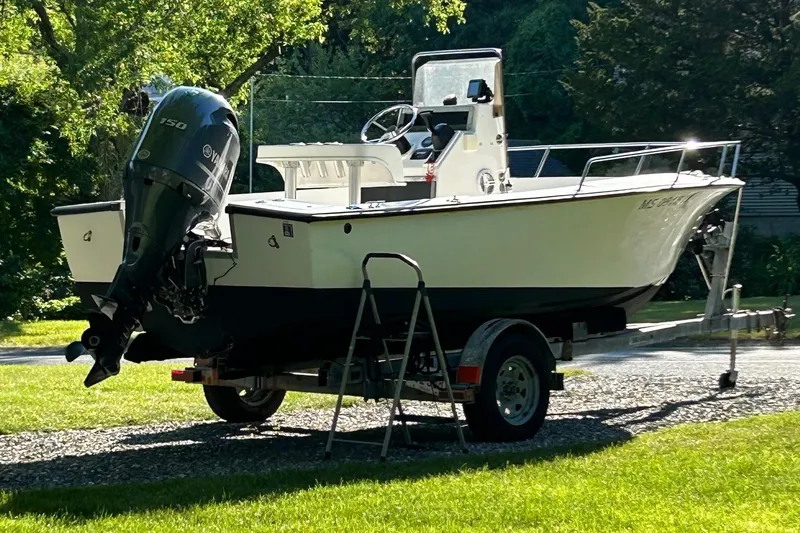 Slide: The Image of 1995 Sailfish 19 boat on trailer, parked on grass, with Yamaha outboard motor. - 8