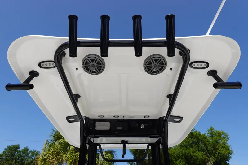 Slide: The Image of 2026 Sea Hunt BX 25 FS boat T-top with rod holders and speakers against blue sky. - 13
