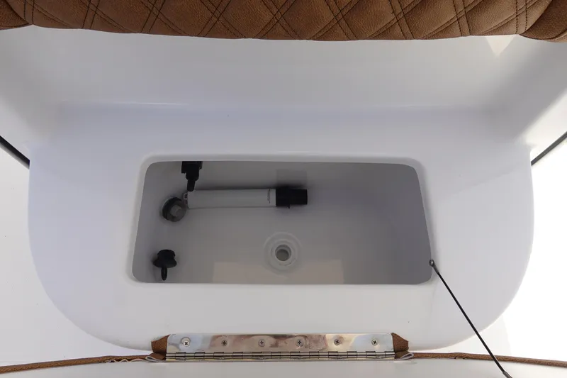 Slide: The Image of Livewell compartment in 2026 Sea Hunt BX 25 FS boat, featuring white interior and brown cushioned seat. - 27