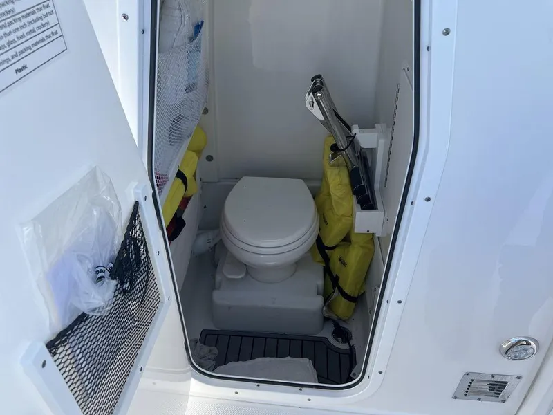 Slide: The Image of 2022 Sea Hunt Gamefish 27 boat interior with compact marine toilet and storage. - 11