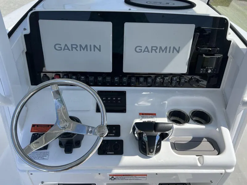 Slide: The Image of 2022 Sea Hunt Gamefish 27 helm with dual Garmin displays and steering wheel. - 13