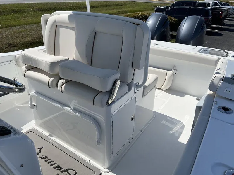 Slide: The Image of 2022 Sea Hunt Gamefish 27 Forward Seating boat interior with dual engines and cushioned seating. - 14