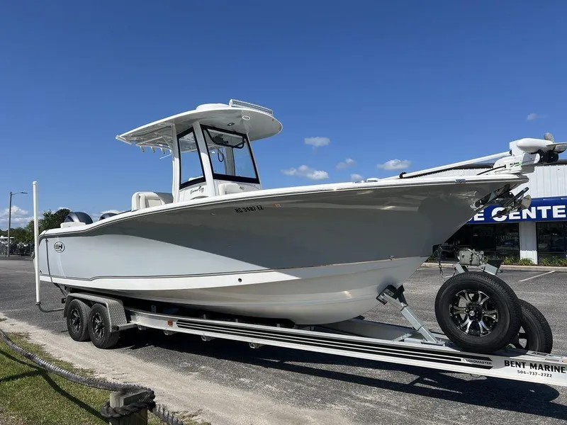 Slide: The Image of 2022 Sea Hunt Gamefish 27 boat on trailer, parked outdoors under clear sky. - 3