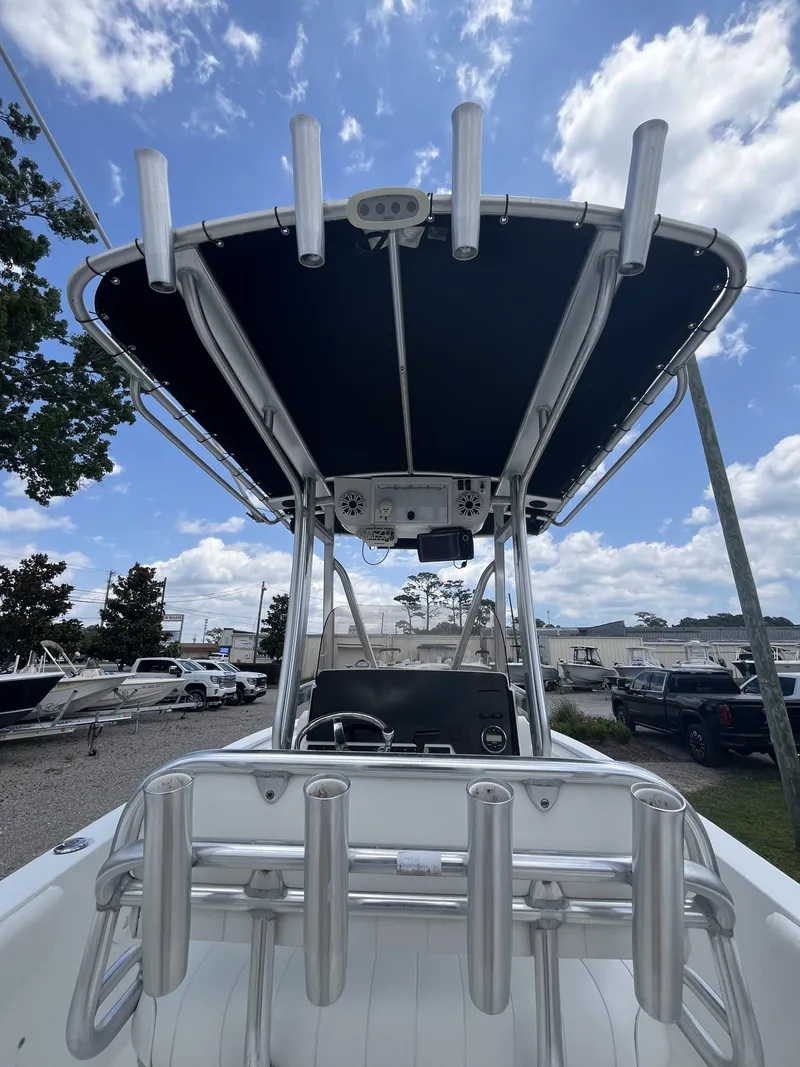 Slide: The Image of 2018 Sea Hunt Triton 210 boat with T-top and rod holders under a blue sky. - 11
