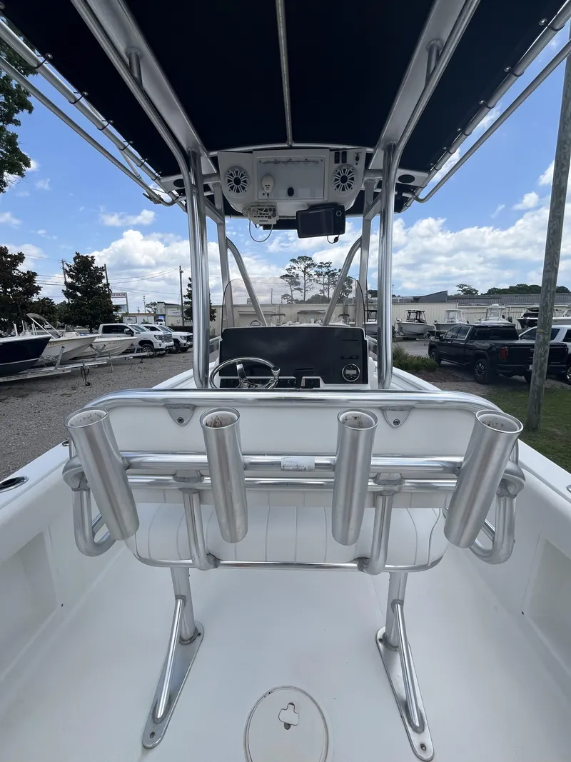 Slide: The Image of 2018 Sea Hunt Triton 210 boat interior with rod holders and console, under a clear sky. - 14