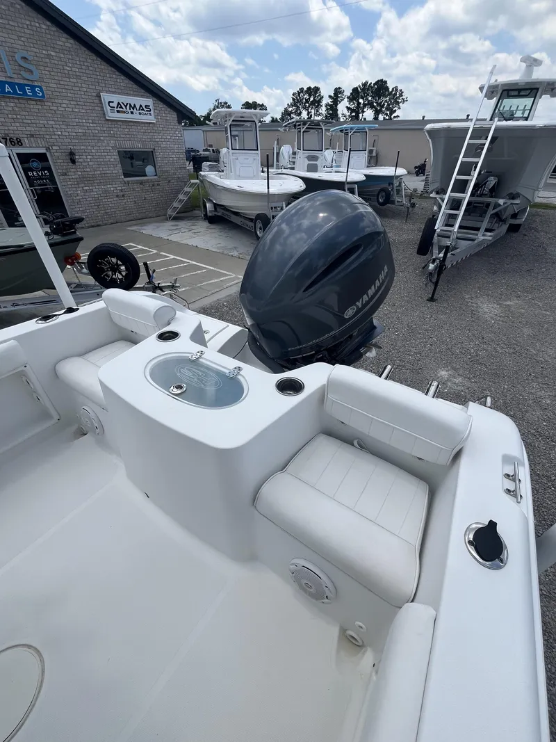 Slide: The Image of 2018 Sea Hunt Triton 210 boat with Yamaha outboard motor, parked at a dealership. - 17