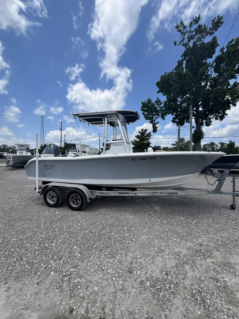 Slide: The Image of 2018 Sea Hunt Triton 210 boat on trailer under a partly cloudy sky. - 4