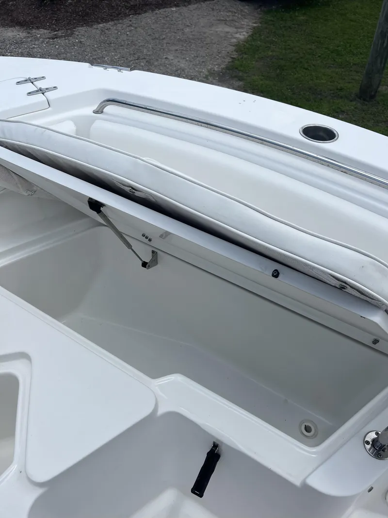 Slide: The Image of 2018 Sea Hunt Triton 210 boat with open storage compartment, white interior. - 7