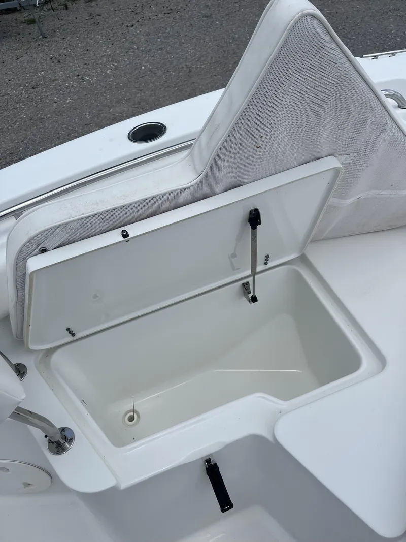 Slide: The Image of 2018 Sea Hunt Triton 210 boat with open storage compartment and cushioned seating. - 8
