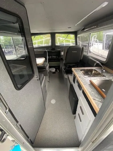 Slide: The Image of 2024 Spartan 2800 Olympia boat interior with kitchenette, seating, and helm. - 3