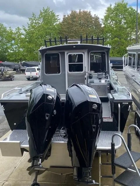 Slide: The Image of 2024 Spartan 2800 Olympia boat with dual outboard motors, docked outdoors. - 4