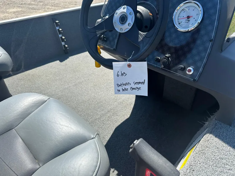 Slide: The Image of Interior of a 2019 Tracker Classic boat with steering wheel and note attached. - 13
