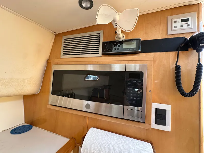 Slide: The Image of 1994 Bertram 30 Express Fisherman interior with microwave, fan, and radio equipment. - 12