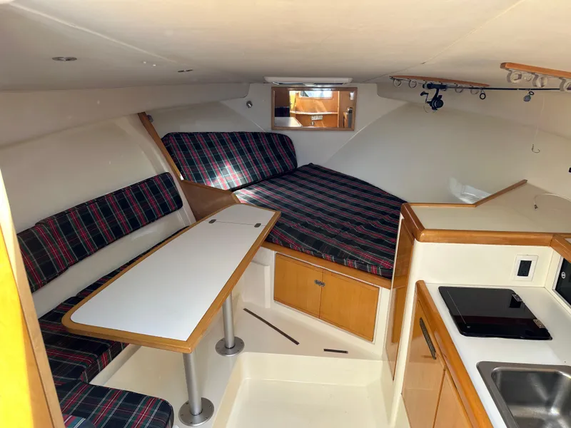 Slide: The Image of 1994 Bertram 30 Express Fisherman cabin with dining area, bed, and kitchenette. - 13