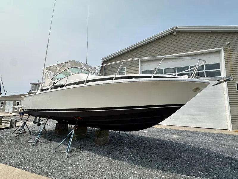 Slide: The Image of 1994 Bertram 30 Express Fisherman boat on stands, outside a garage. - 21