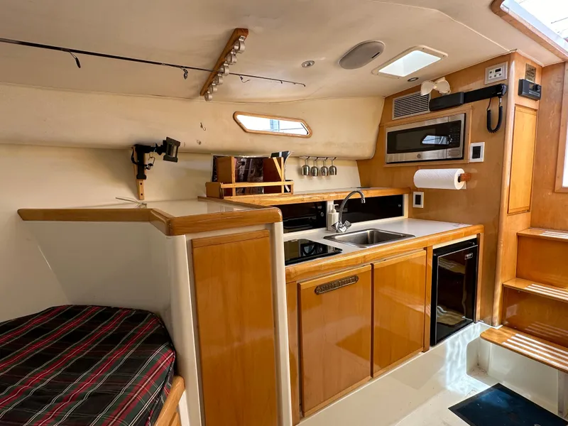 Slide: The Image of Interior of a 1994 Bertram 30 Express Fisherman with kitchen and seating area. - 5