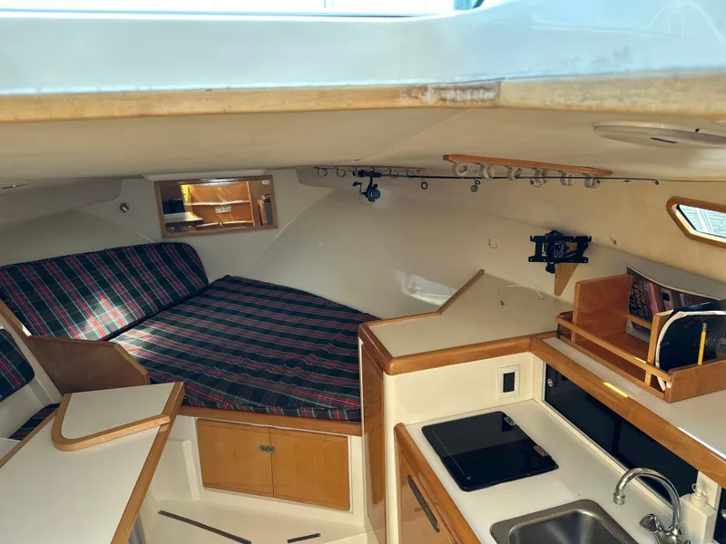 Slide: The Image of 1994 Bertram 30 Express Fisherman cabin with kitchenette and plaid bedding. - 7