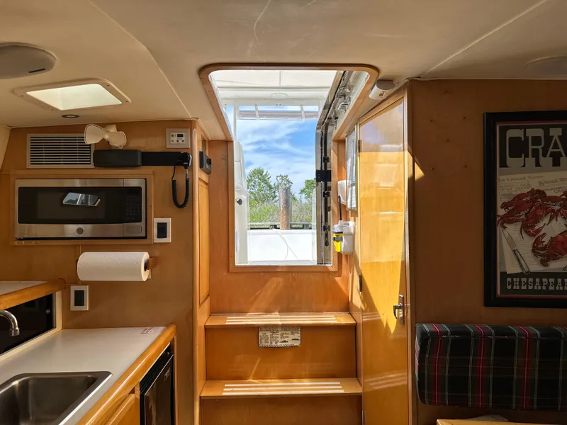 Slide: The Image of Interior of a 1994 Bertram 30 Express Fisherman boat with kitchen amenities. - 9