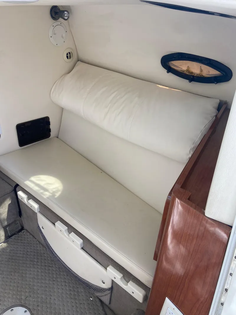 Slide: The Image of 2008 Ebbtide 2700 Cuddy Bow Rider interior with white cushioned seating. - 12