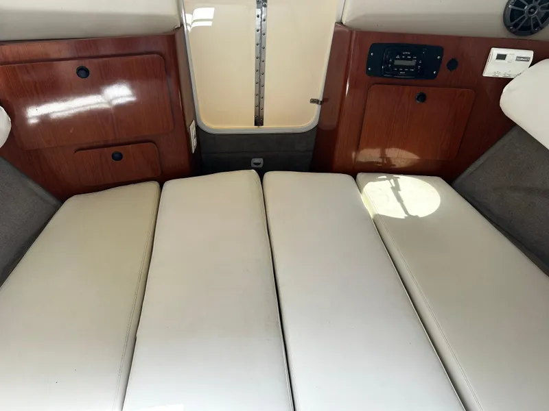 Slide: The Image of 2008 Ebbtide 2700 Cuddy Bow Rider interior with cushioned seating and wooden cabinetry. - 13