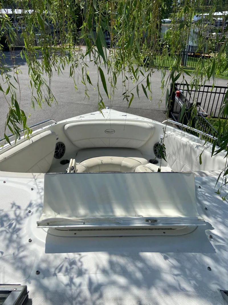 Slide: The Image of 2008 Ebbtide 2700 Cuddy Bow Rider boat under leafy branches, featuring spacious seating. - 16