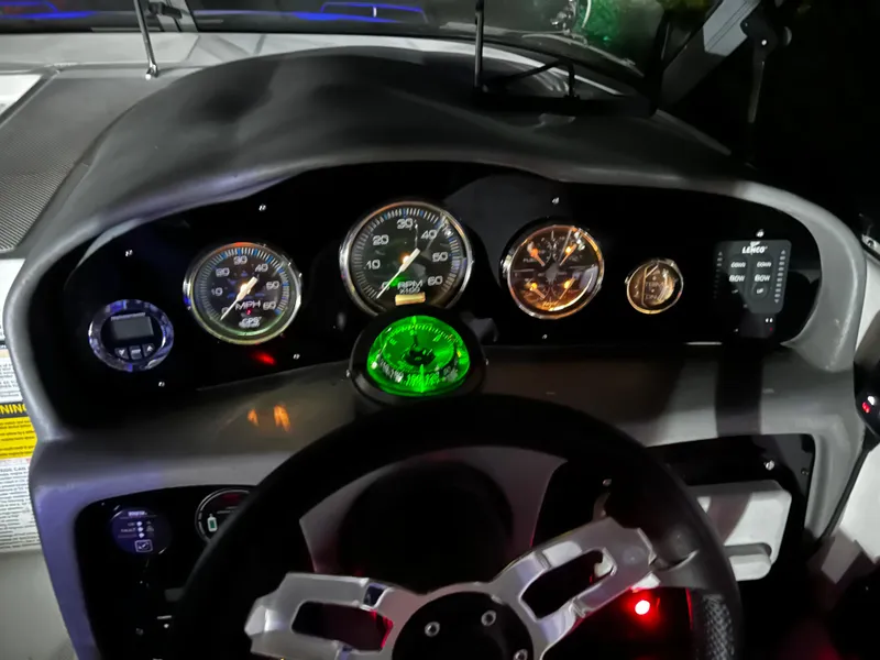 Slide: The Image of Dashboard of a 2008 Ebbtide 2700 Cuddy Bow Rider with illuminated gauges and steering wheel. - 6
