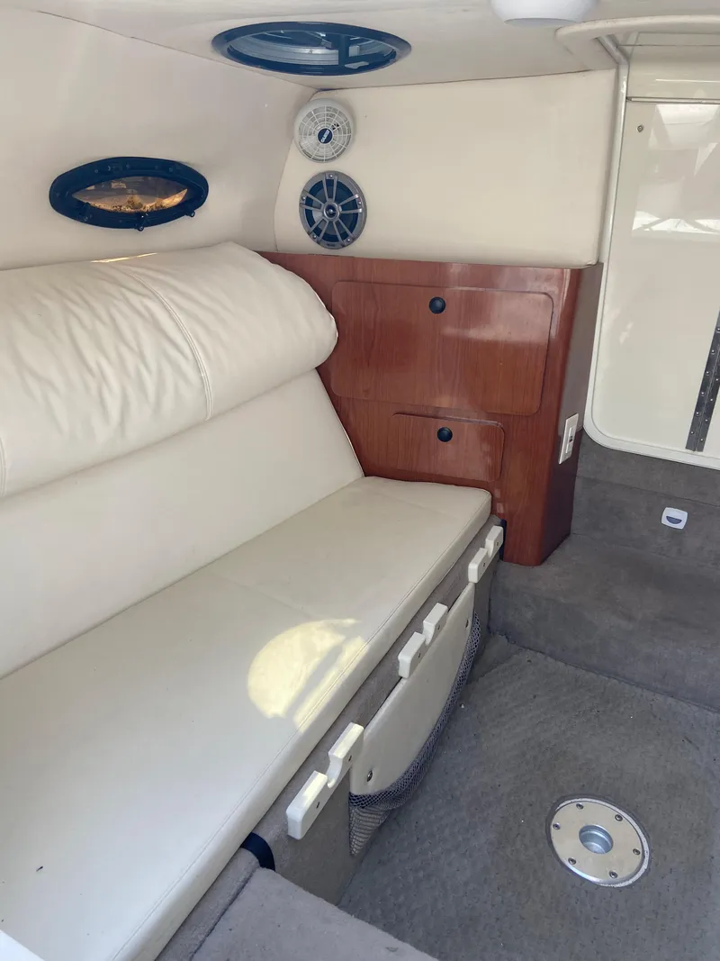 Slide: The Image of 2008 Ebbtide 2700 Cuddy Bow Rider interior with white seating and wooden cabinetry. - 9