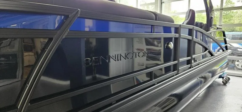 Slide: The Image of 2025 Bennington Q 25 QFBA pontoon boat with sleek blue and black design. - 10