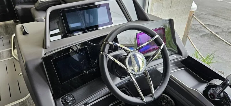 Slide: The Image of 2025 Bennington Q 25 QFBA boat dashboard with modern steering and digital displays. - 5