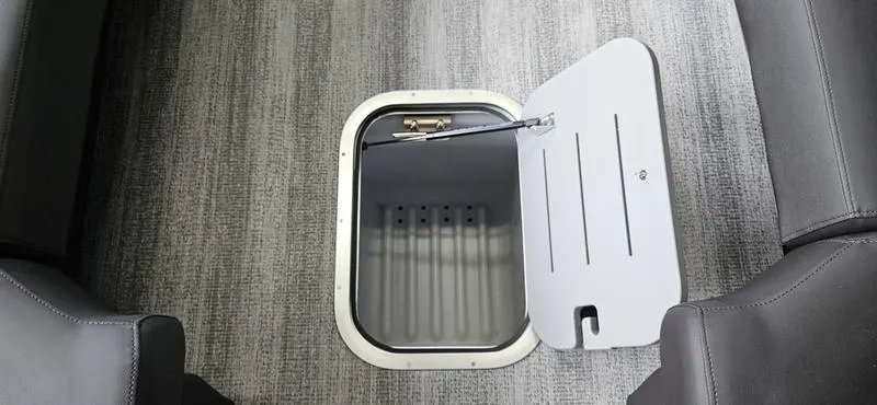 Slide: The Image of 2025 Bennington Q 25 QFBA boat storage compartment with open hatch on gray carpet. - 9