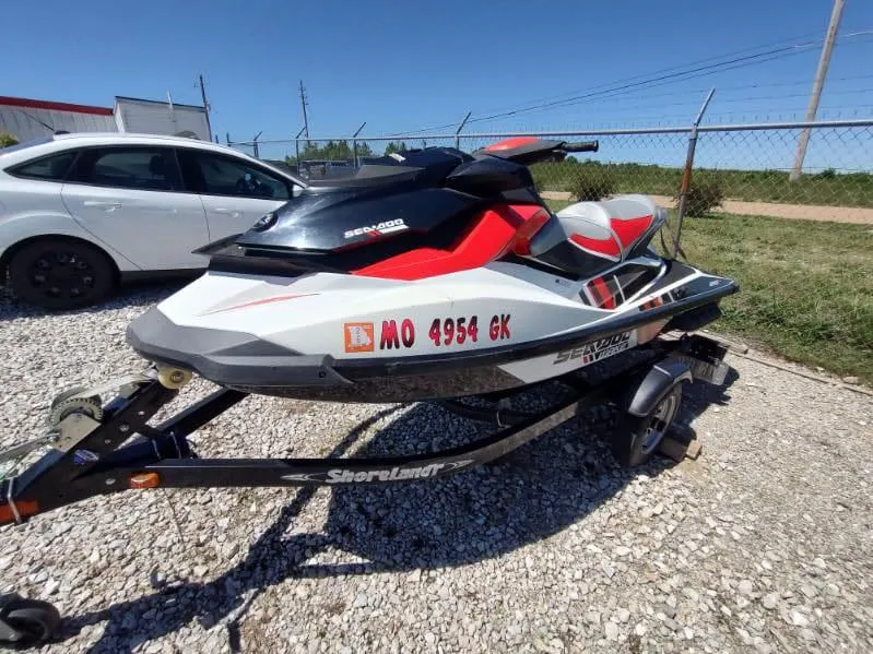 The Image of 2013 Sea-Doo Wake 155 jet ski on trailer, parked on gravel. - 0