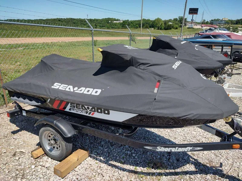 Slide: The Image of 2013 Sea-Doo Wake 155 jet ski covered on trailer, parked outdoors. - 2