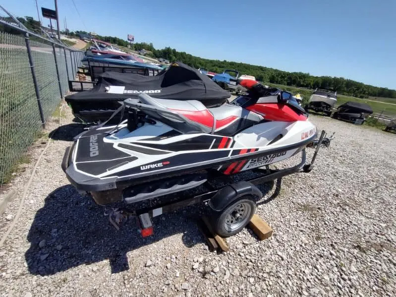 Slide: The Image of 2013 Sea-Doo Wake 155 jet ski on a trailer, parked on gravel. - 8