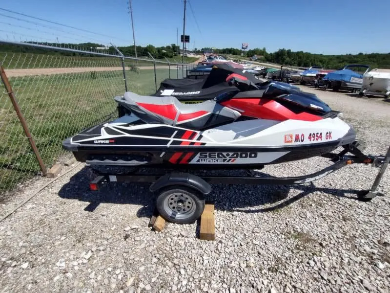 Slide: The Image of 2013 Sea-Doo Wake 155 jet ski on trailer, parked outdoors. - 9