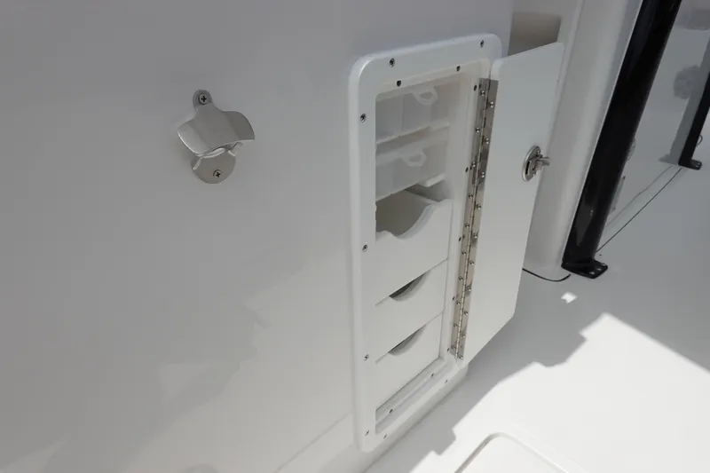 Slide: The Image of 2026 Sea Hunt Gamefish 28 FS storage compartment with open door and organized shelves. - 19