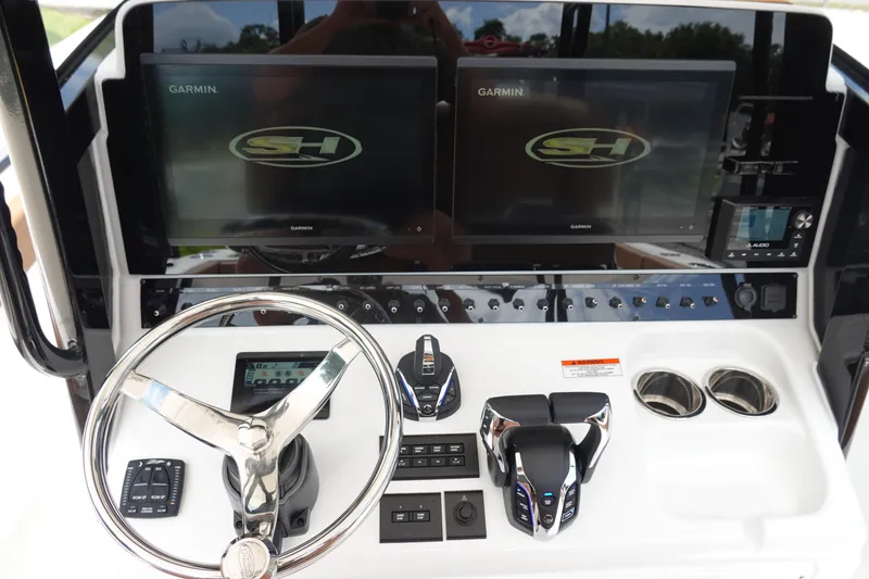 Slide: The Image of 2026 Sea Hunt Gamefish 28 FS boat console with Garmin displays and steering wheel. - 26