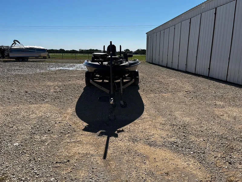 Slide: The Image of 2020 Bass Cat Lynx boat parked on gravel near a large white building. - 2
