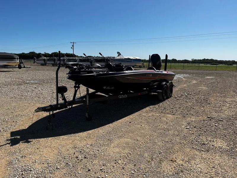 Slide: The Image of 2020 Bass Cat Lynx boat on a gravel lot under clear blue sky. - 3