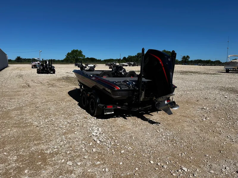 Slide: The Image of 2020 Bass Cat Lynx boat on a gravel lot under clear blue sky. - 4