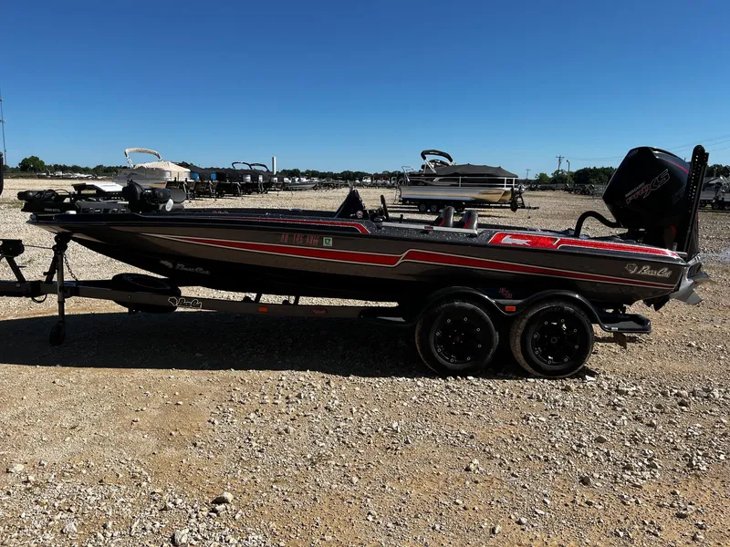Slide: The Image of 2020 Bass Cat Lynx boat on trailer, parked on gravel lot under clear blue sky. - 5