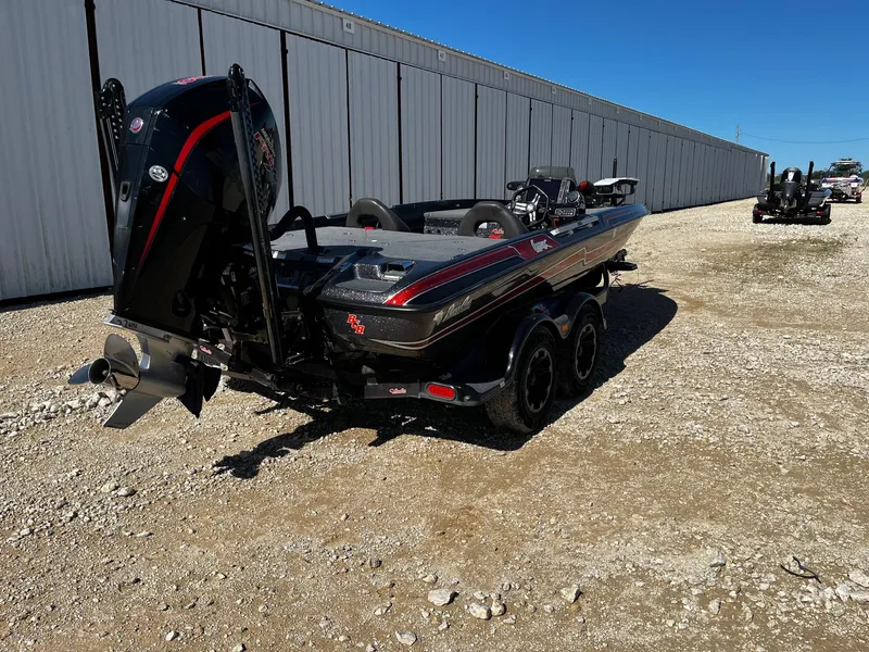 Slide: The Image of 2020 Bass Cat Lynx boat parked on gravel near a large warehouse. - 6