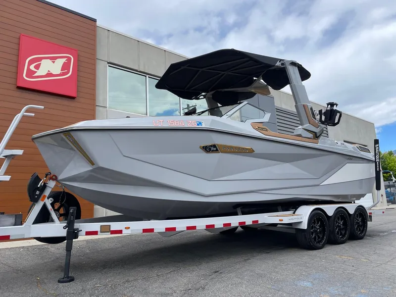 Slide: The Image of 2024 Nautique Super Air Nautique G25 Paragon boat on trailer, outside dealership. - 2