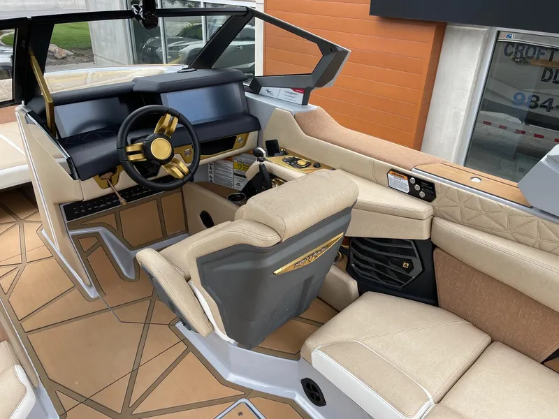 Slide: The Image of 2024 Nautique Super Air Nautique G25 Paragon interior with luxurious beige seating and modern dashboard. - 6