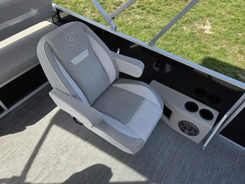 Slide: The Image of Captain's chair on 2025 Godfrey Xperience 2286 SFLX Sport Tube boat, featuring cup holders and speaker. - 14