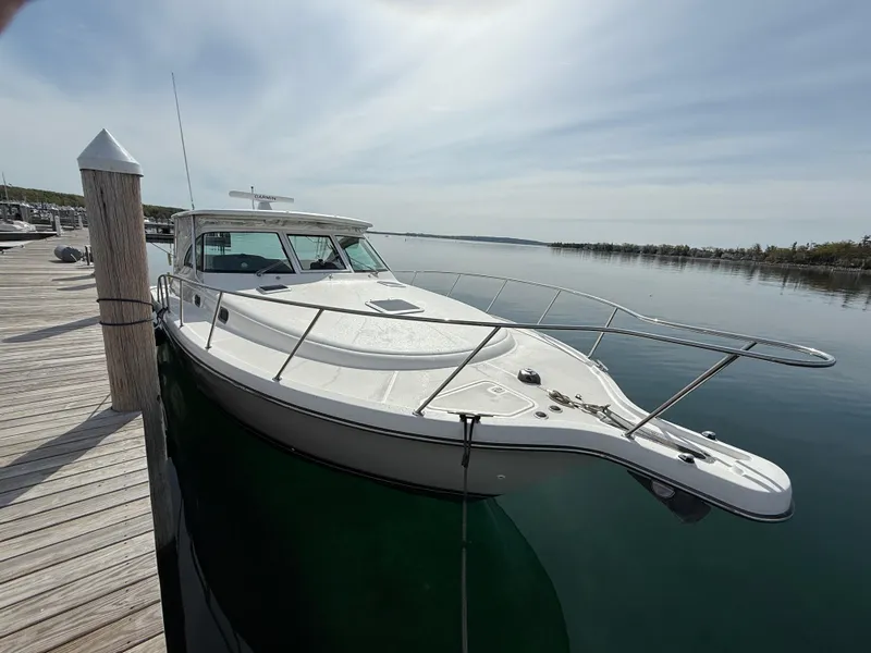 Slide: The Image of 2002 Pursuit 3800 Express boat docked on calm water under a clear sky. - 10