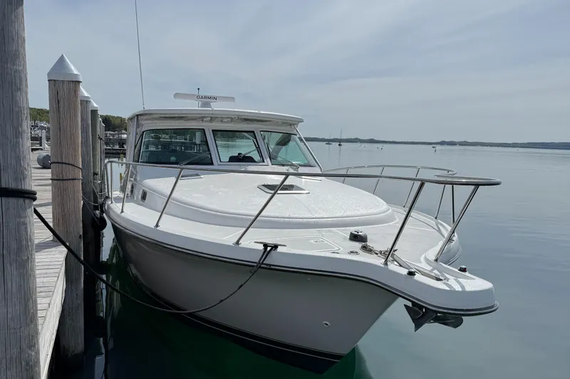 Slide: The Image of 2002 Pursuit 3800 Express boat docked on calm water. - 11