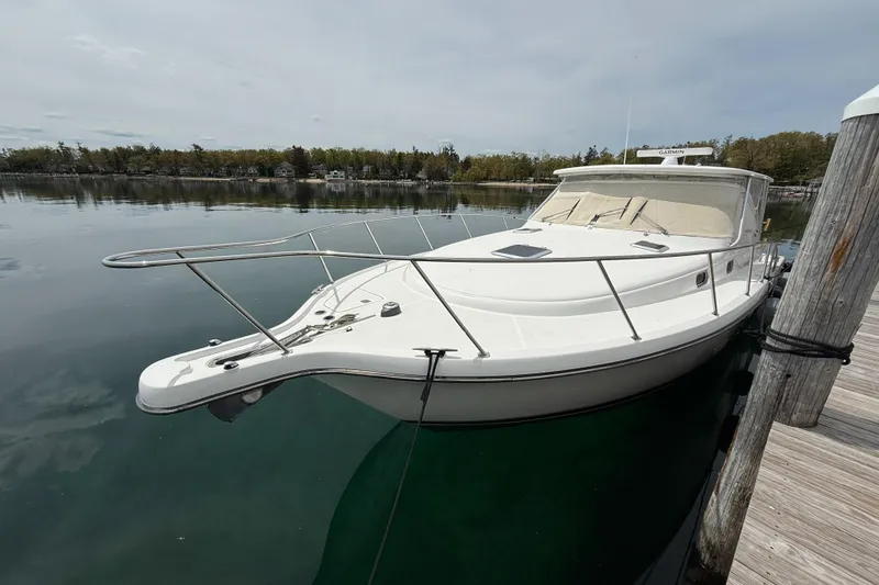 Slide: The Image of 2002 Pursuit 3800 Express boat docked on calm water, side view. - 13
