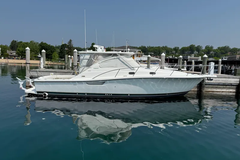 Slide: The Image of 2002 Pursuit 3800 Express boat docked in a serene marina setting. - 15